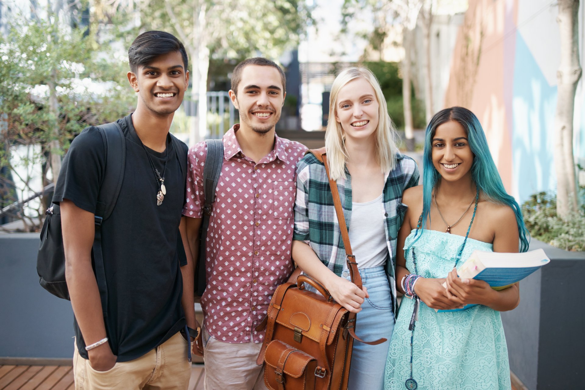 The best part of campus are my friends. Group of multiracial students looking at camera on territory of university campus. Concept of education and learning. Idea of student lifestyle. Friendship. Black man with electric scooter